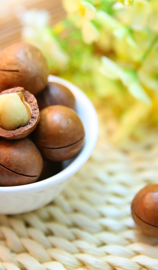 Орехи макадамия на столе с цветами