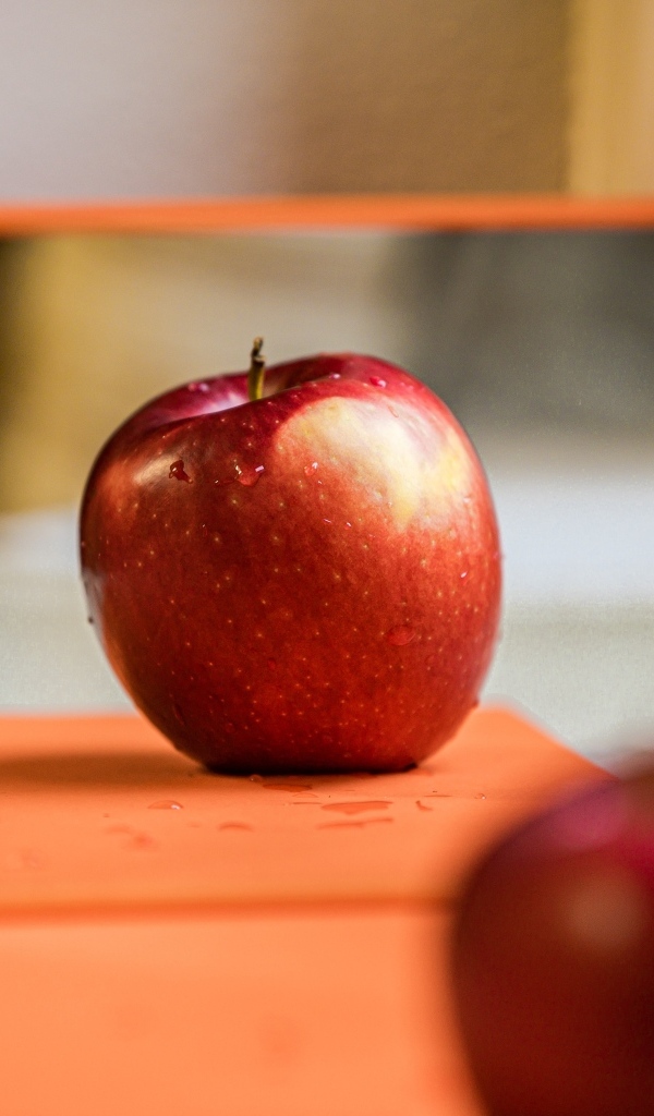 Больше красное яблоко отражается в зеркале 