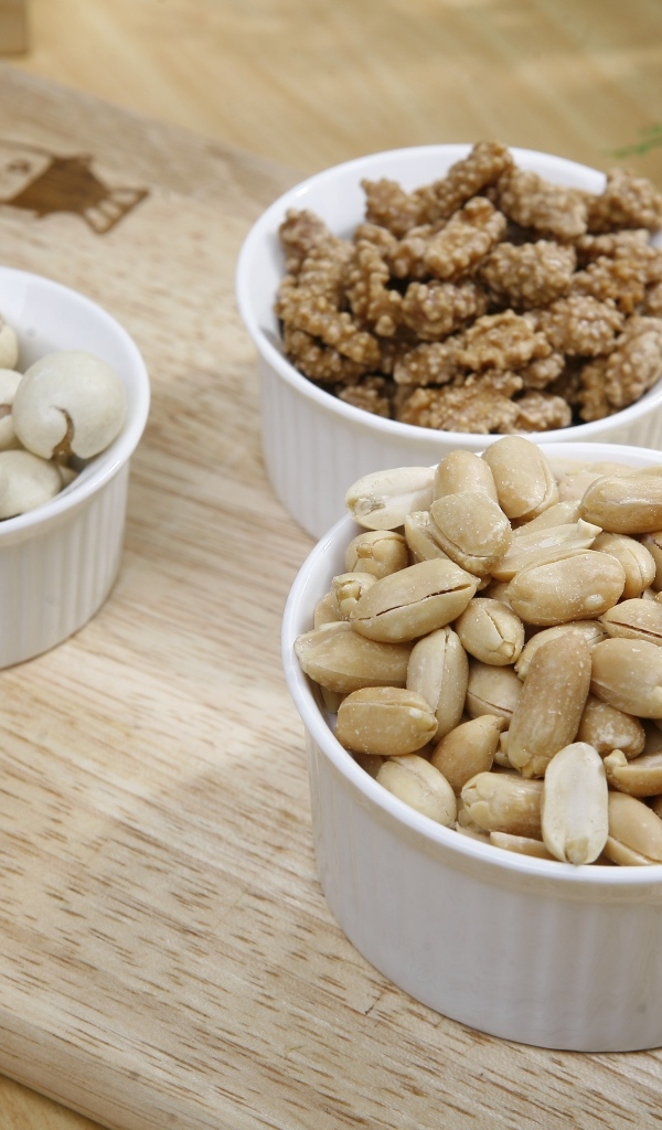 Орехи в белой посуде на доске