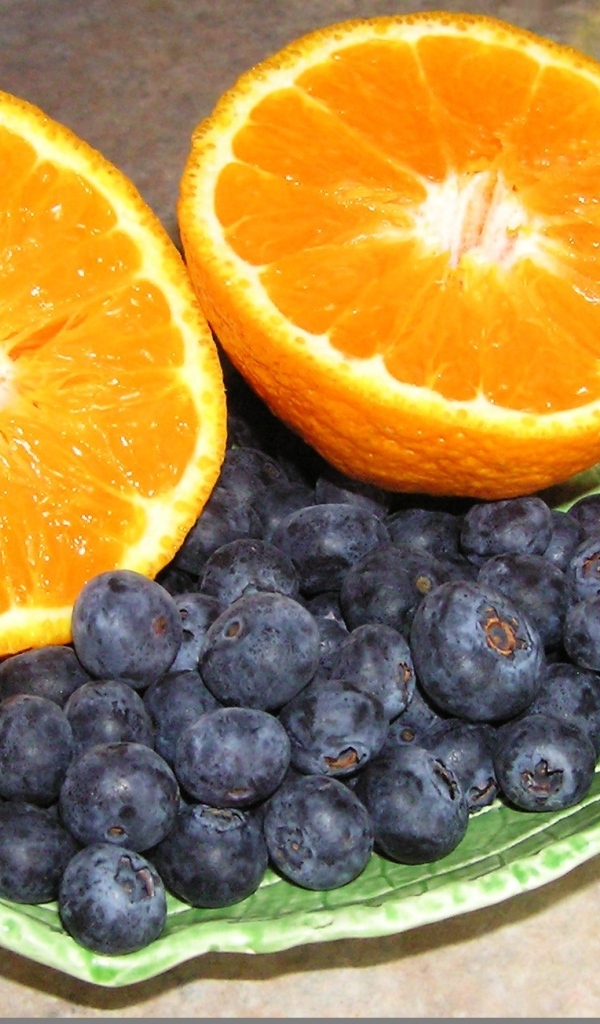 Половинки апельсина с ягодами черники на столе