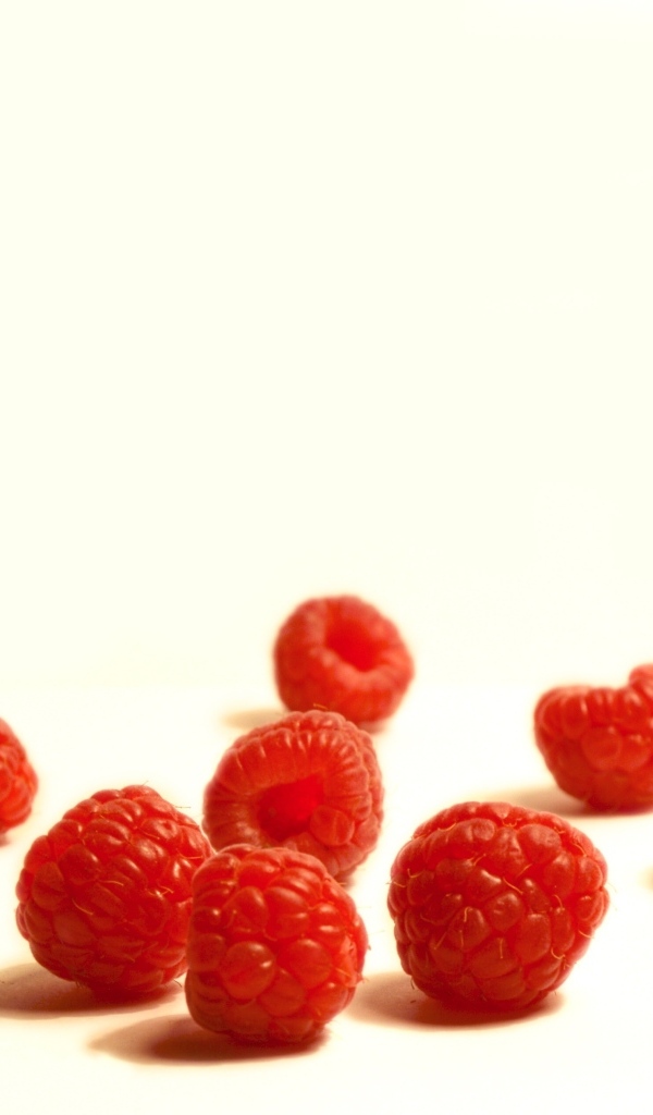 Красные ягоды малины на белом фоне крупным планом