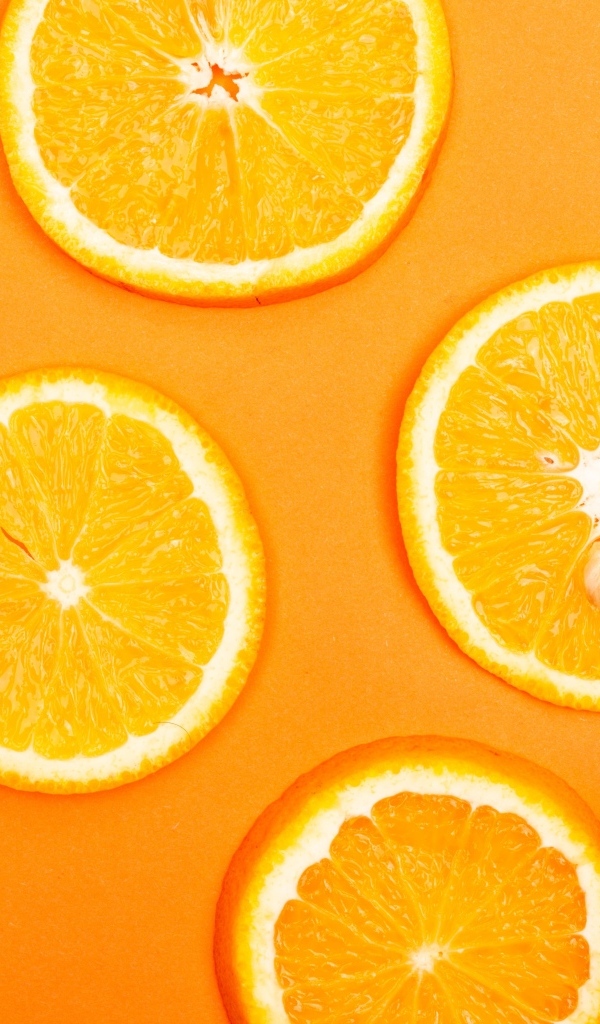 Спелый апельсин на оранжевом фоне