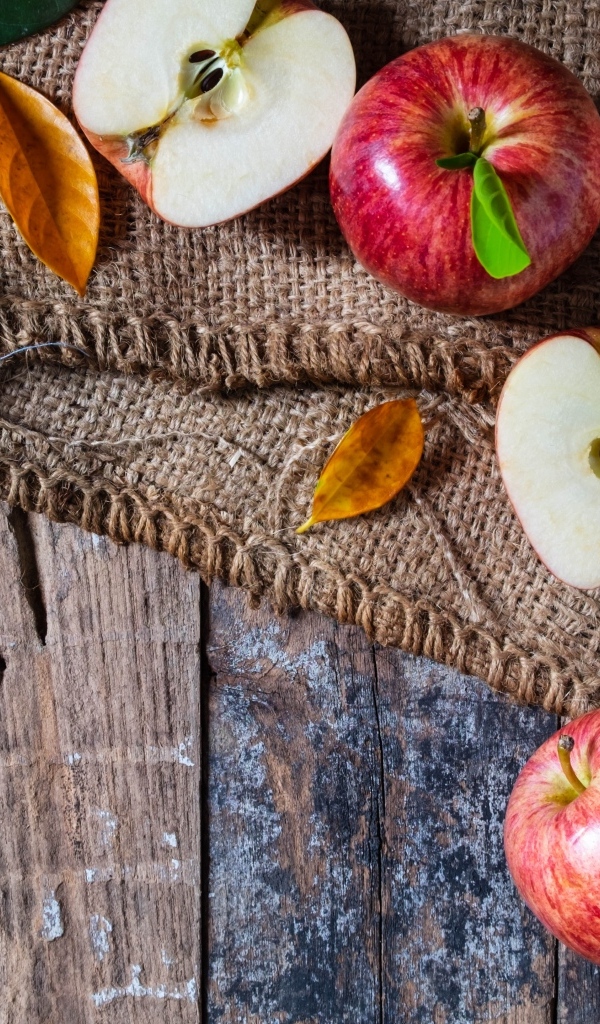 Спелые красные яблоки на столе с мешком