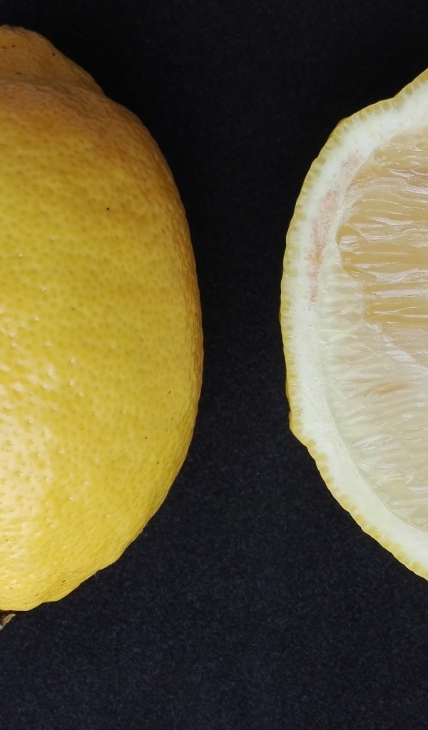 Разрезанный лимон на черном столе