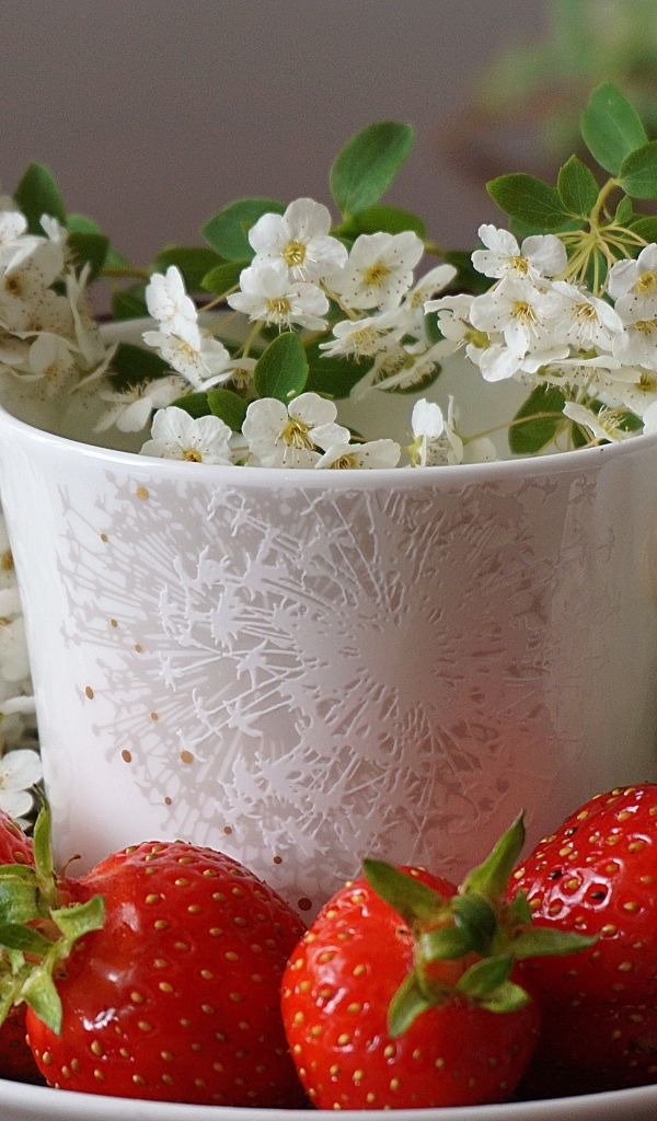 Клубника на тарелке с чашкой и белыми цветами