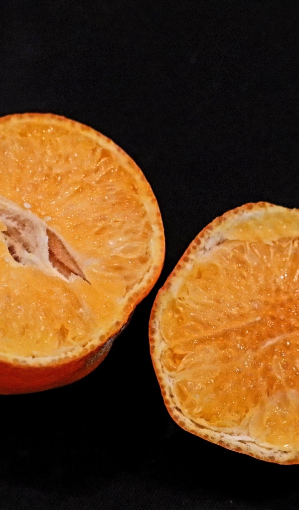 Мандарин на черном фоне крупным планом