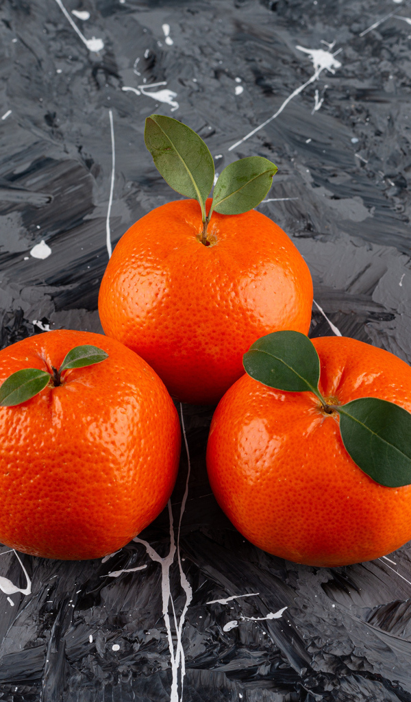 Три мандарина на сером столе