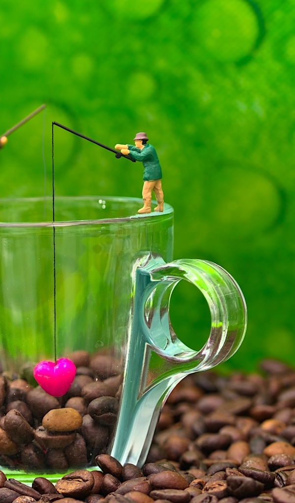 Две фигурки на стеклянной чашкой с кофейными зернами