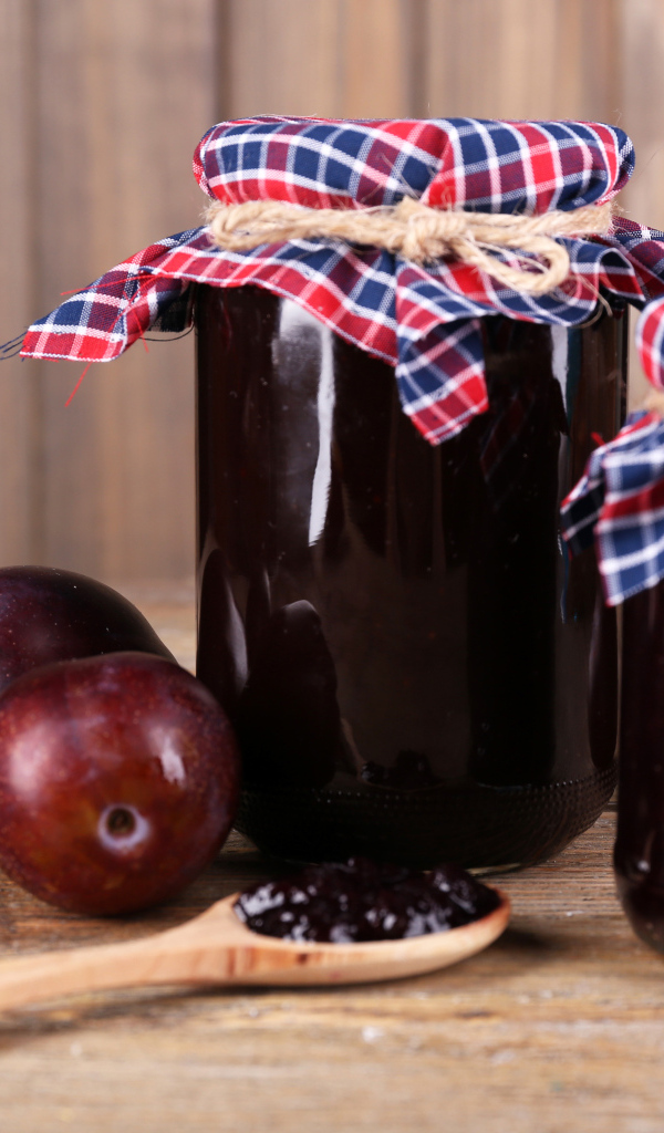 Две банки джема на столе со сливами