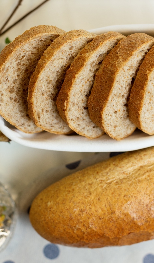 Батон нарезанный на столе с цветами