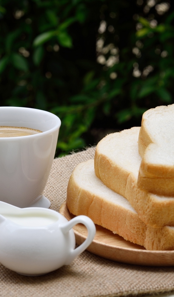Хлеб на столе с кофе и молоком