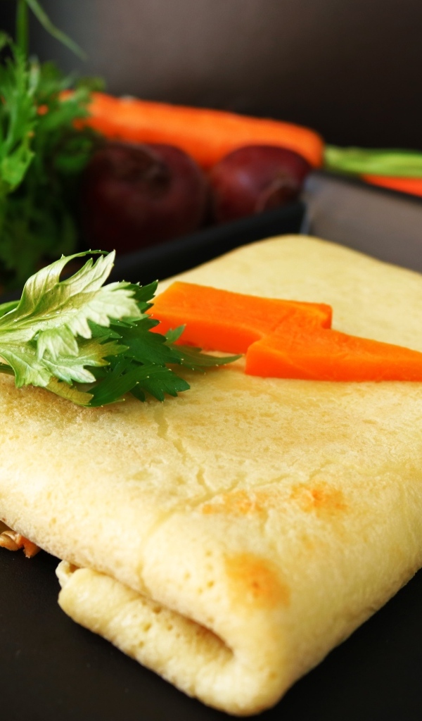 Блинчик на тарелке с морковью и веточками петрушки