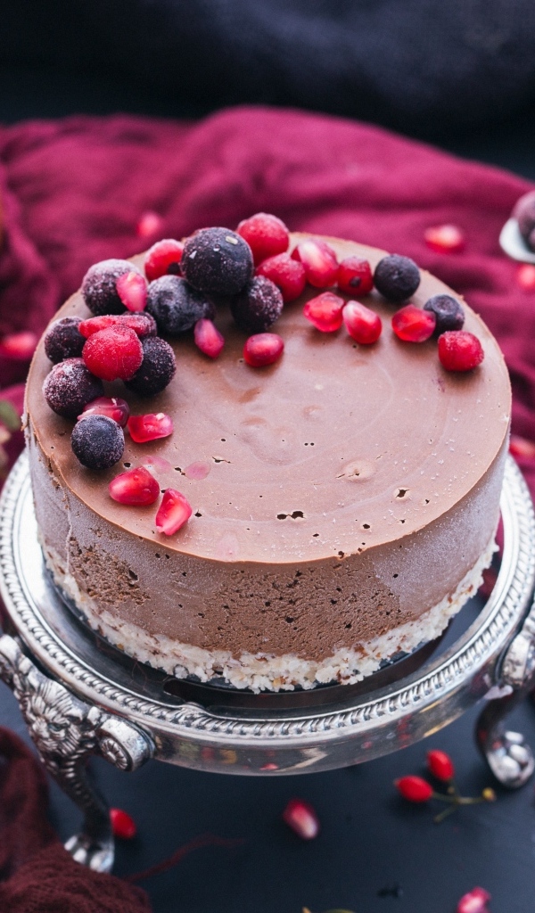 Аппетитный торт с гранатами на столе 