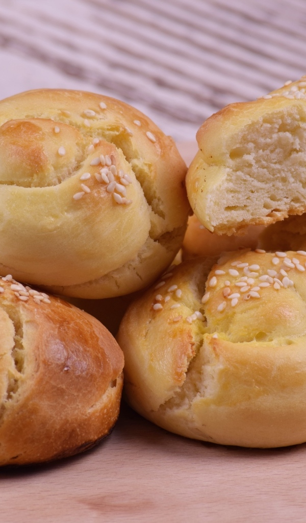 Аппетитные сладкие булочки с кунжутом на столе