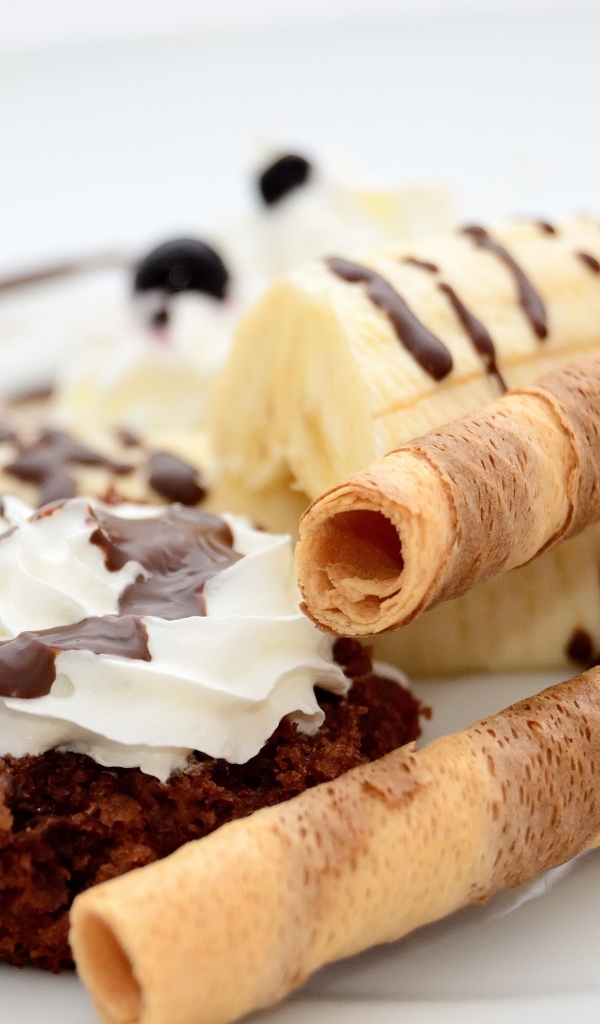 Банан на тарелке с трубочками и кексом