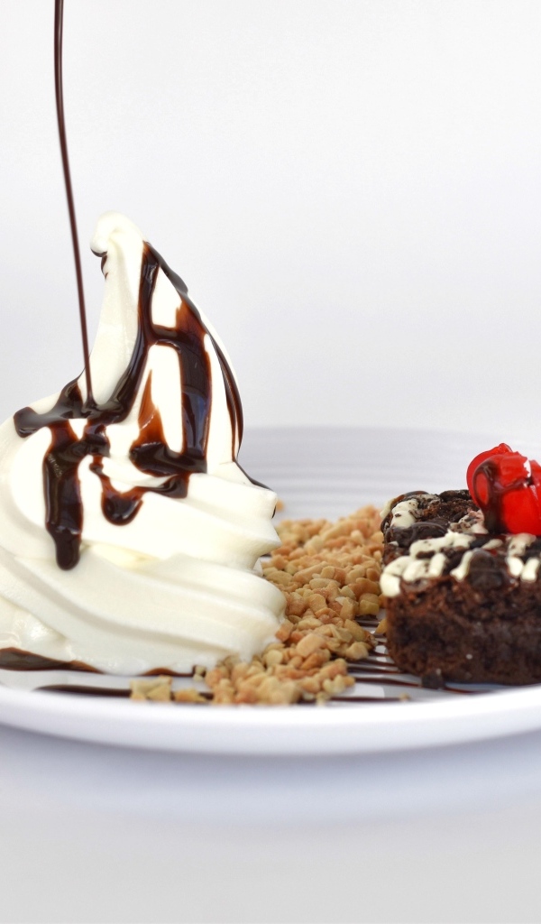 Пирожное со взбитыми сливками на тарелке на белом фоне