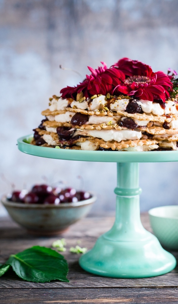 Торт с черешней и цветами герберы на столе