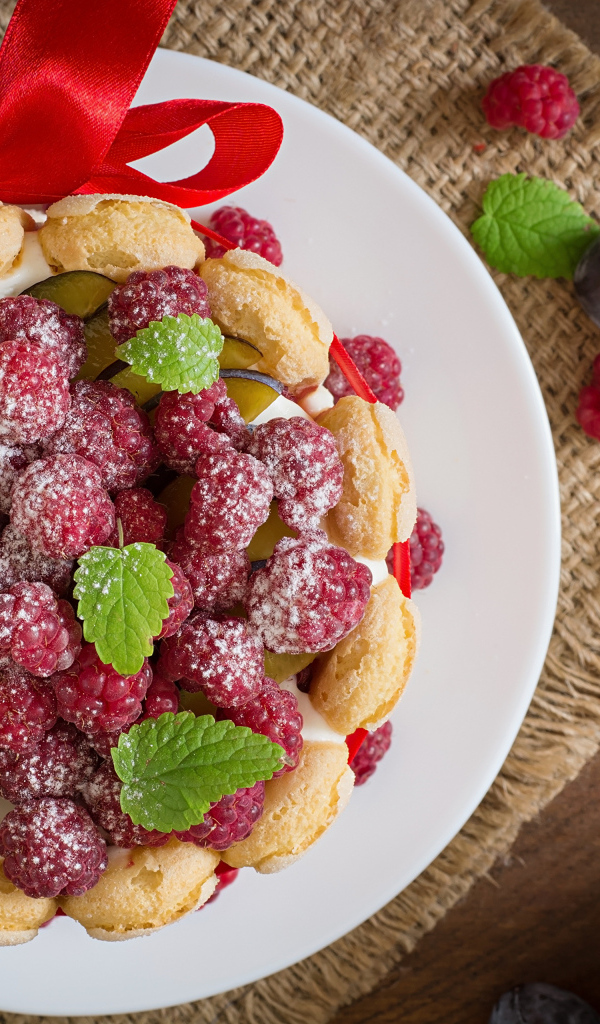 Пирожное с кремом и ягодами малины с ленточкой