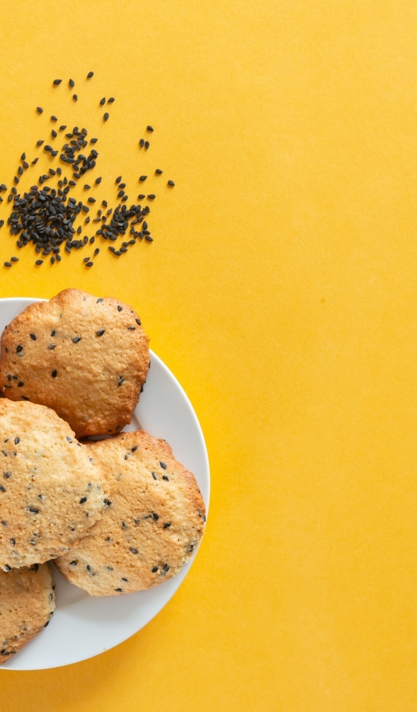 Печенье на желтом фоне с кунжутом и миндальным орехом