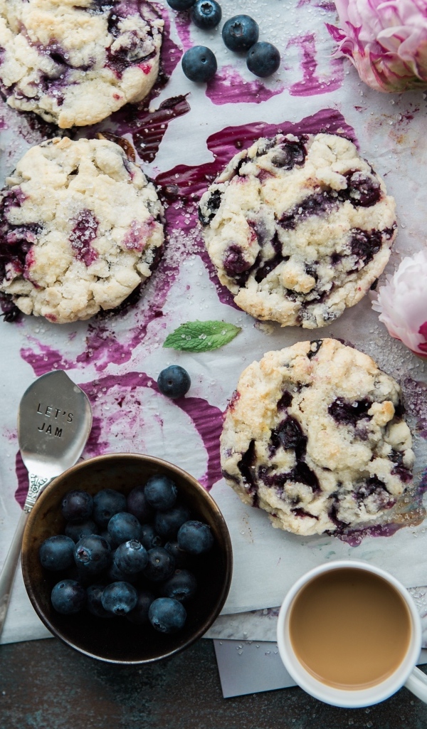 Печенье с ягодами черники на столе с цветами и кофе