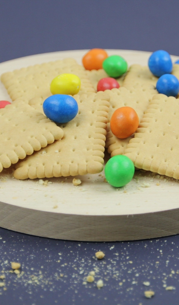 Печенье с разноцветными конфетами на сером фоне