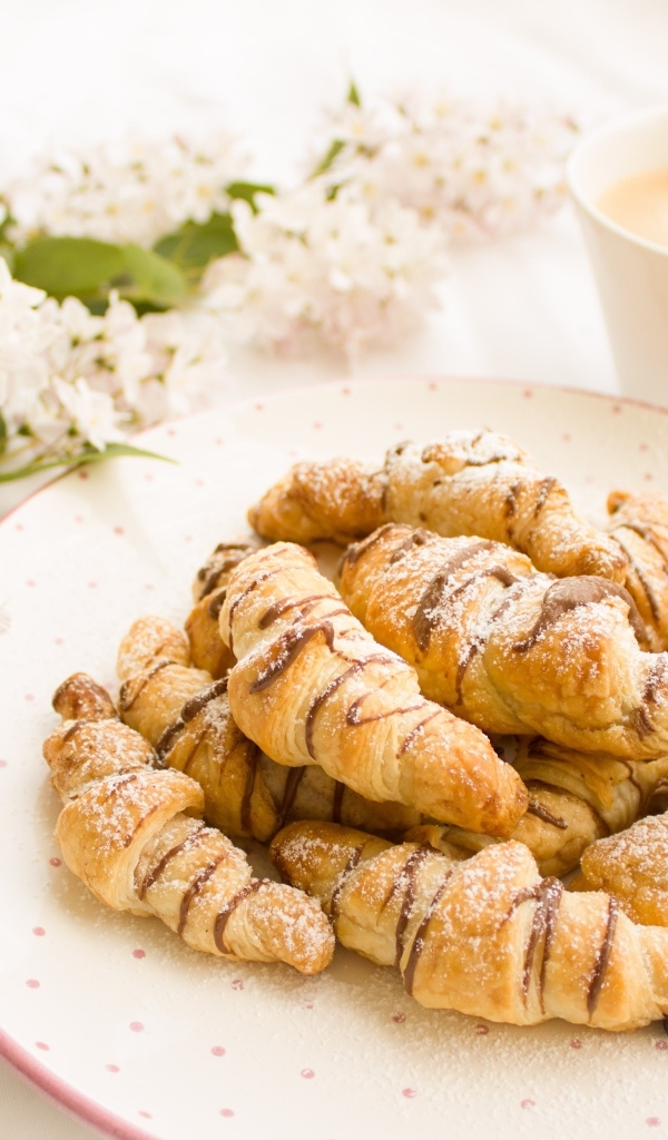 Круассаны на столе с кофе и цветами