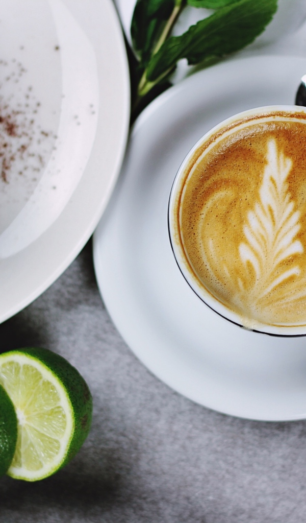 Чашка кофе на столе с пирожным и лаймом