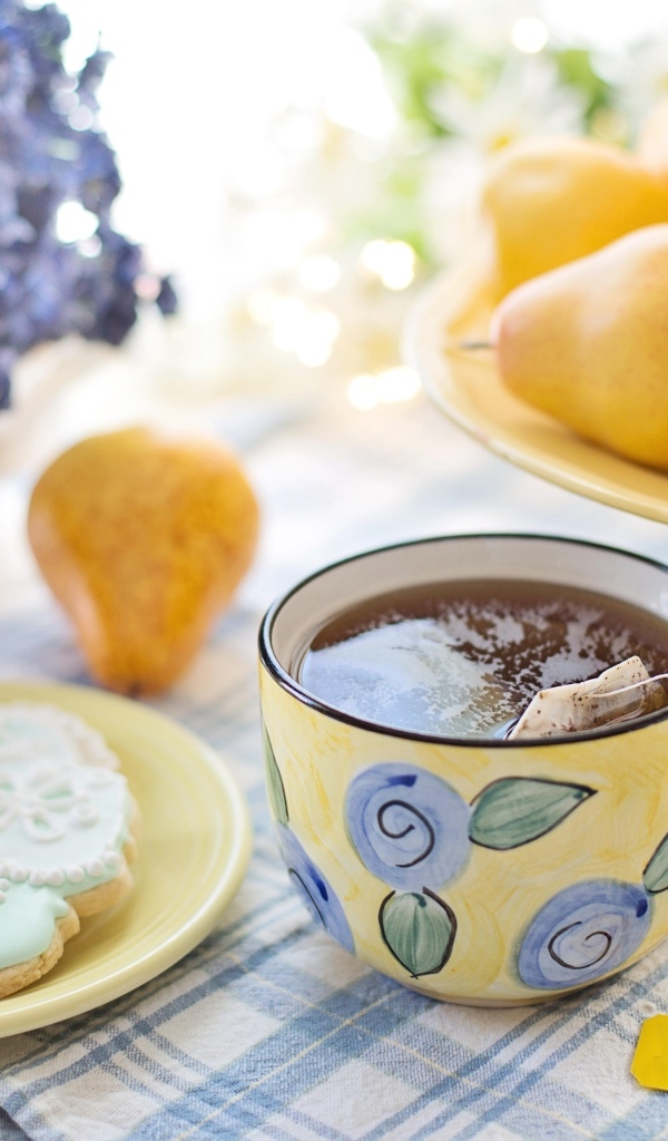 Чашка чая на столе с грушами и печеньем