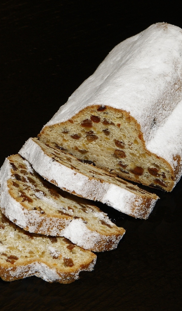 Кекс с изюмом и сахарной пудрой на черном фоне