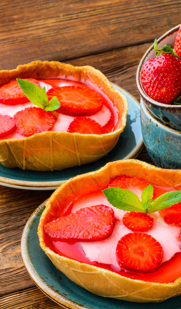 Вкусные пирожные с ягодами клубники на тарелке