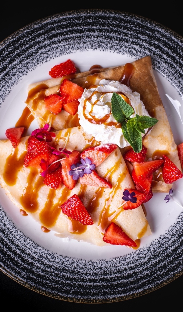 Вкусные сладкие блинчики на тарелке с ягодами