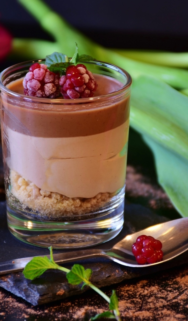 Десерт в стакане на столе с тюльпаном