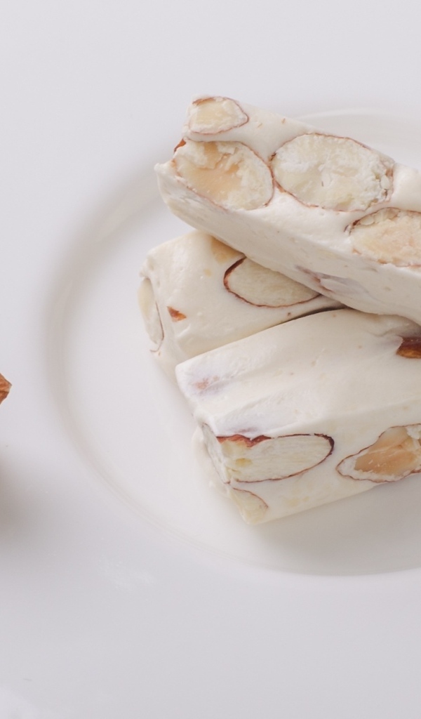 Десерт нуга с миндальными орехами на тарелке 