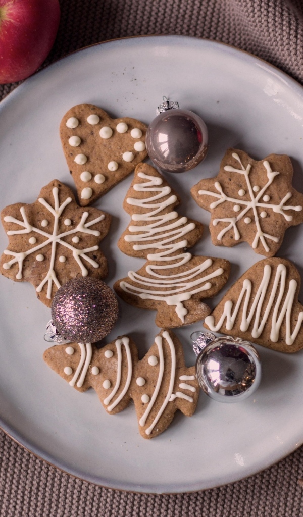 Праздничное печенье на столе с яблоками и шишками