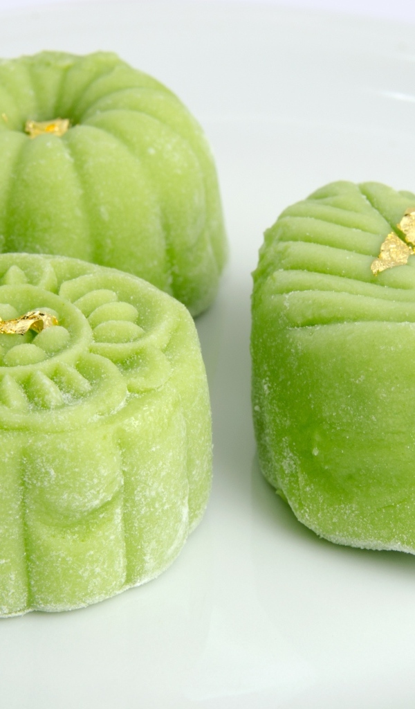 Зеленые конфеты на белой тарелке