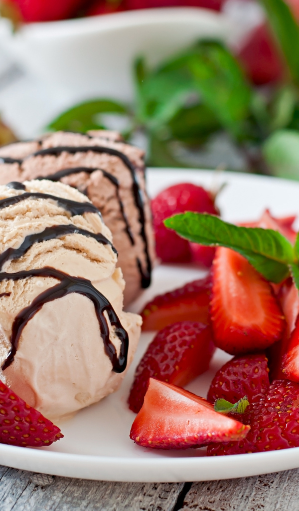 Шарики мороженого на тарелке с кусочками клубники