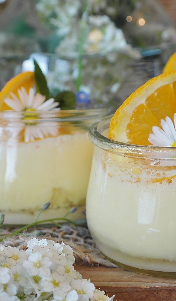 Лимонный крем в стеклянных банках на столе с цветами