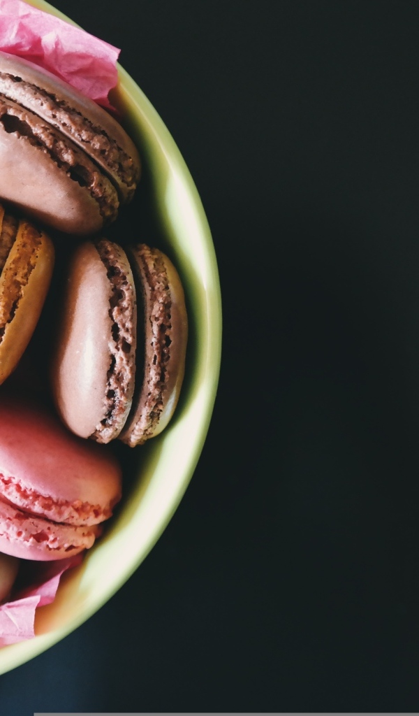 Десерт макарун в миске на черном фоне