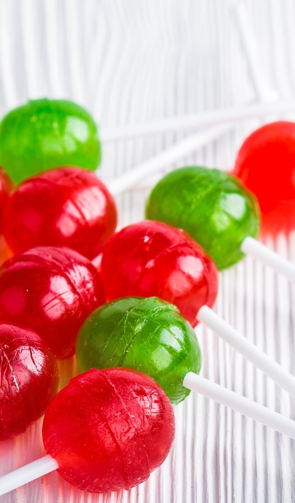 Разноцветные леденцы на палочке лежат на столе