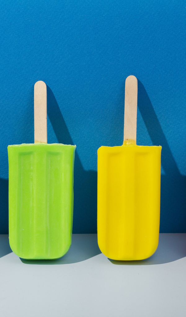 Разноцветное фруктовое мороженое на фоне голубой стены