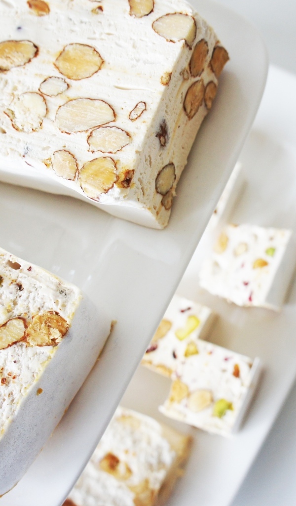 Нуга с орехами на белой тарелке