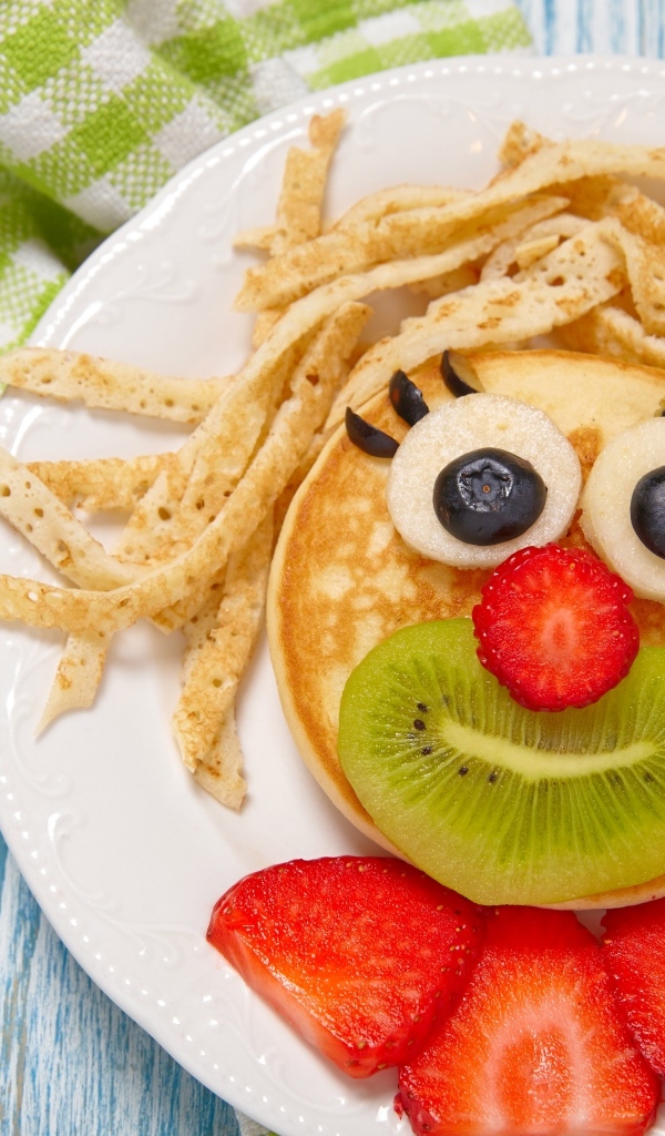 Блины с ягодами на тарелке для ребенка