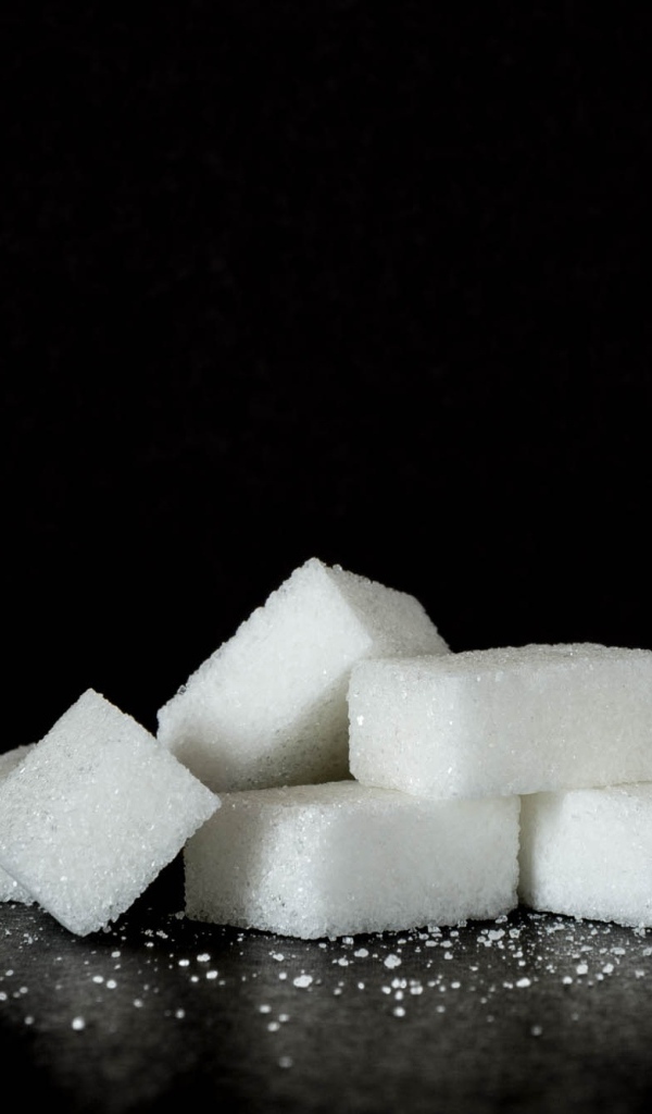 Кусочки сахара на черном фоне