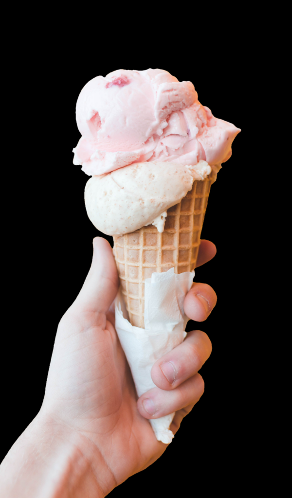 Розовое мороженое в рожке в руке на черном фоне