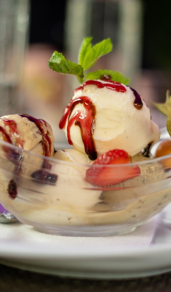 Шарики фруктового мороженого в стеклянной пиале на столе