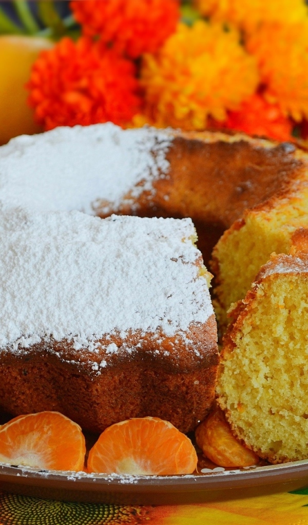 Сладкий пирог на столе с мандаринами и апельсинами