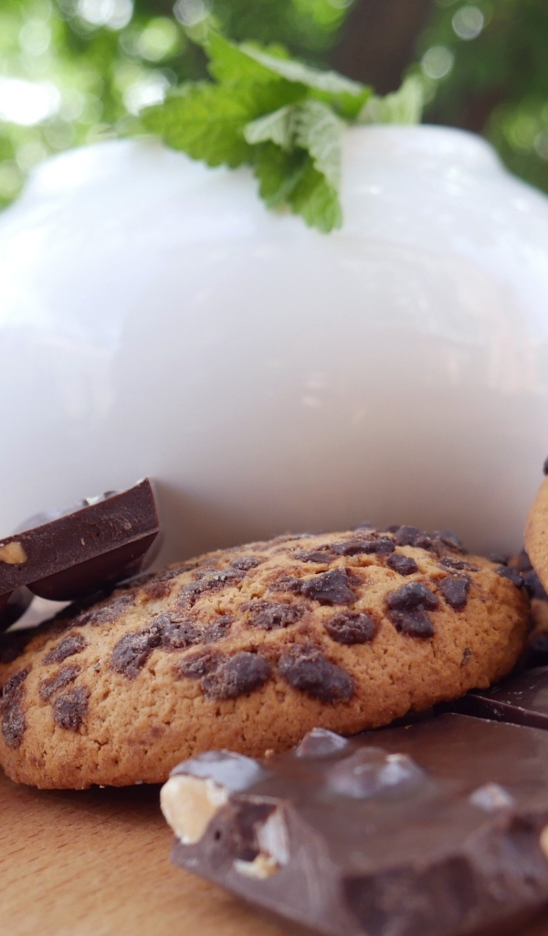 Чайник на столе с печеньем и шоколадом