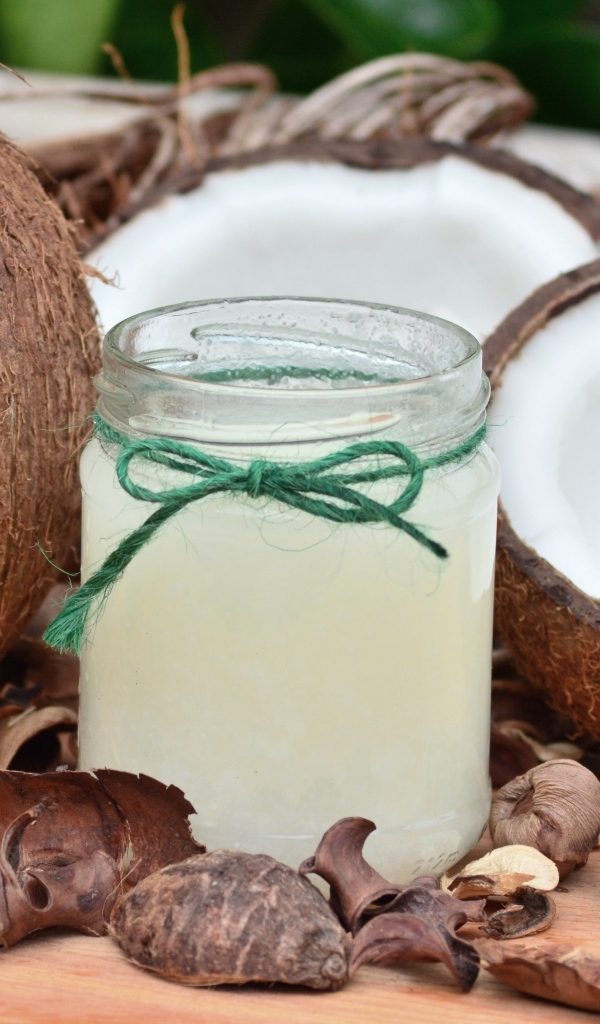 Кокосовое молоко в банке на столе с фруктами