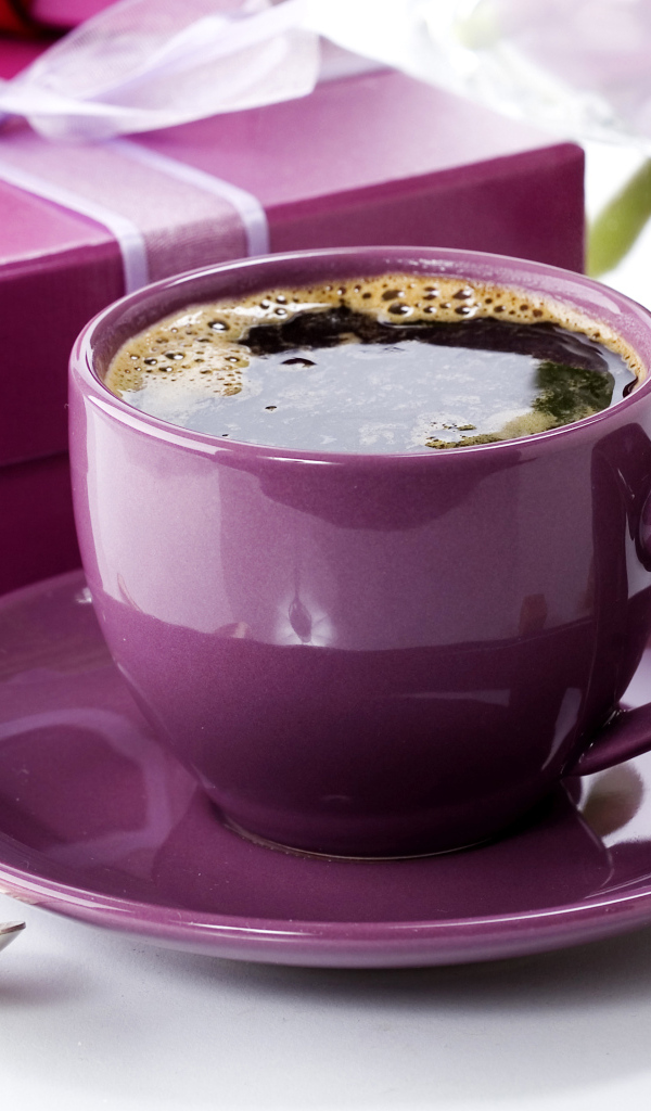 Чашка кофе с подарками и цветами на столе