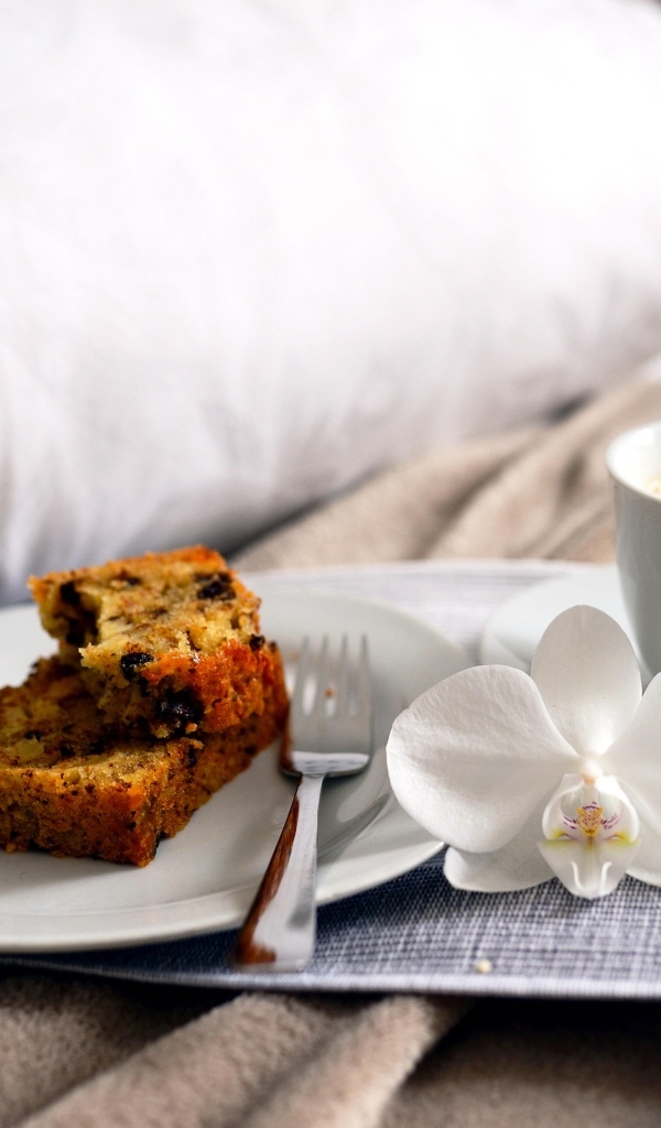 Чашка кофе с цветком орхидеи и кусочками кекса